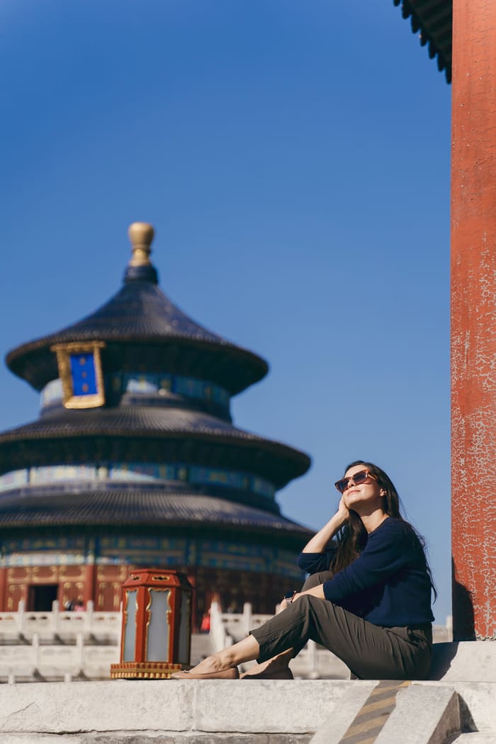 Mujer con un edificio de Beijing de fondo